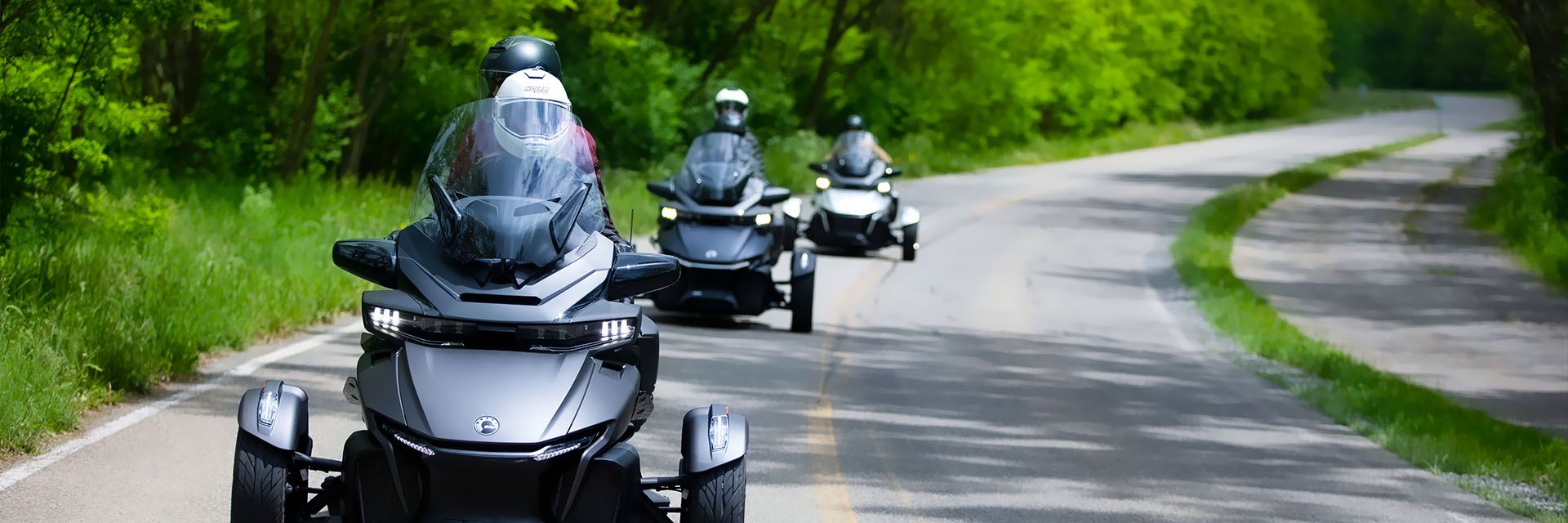 3 Spyder motorcycles driving down the road
