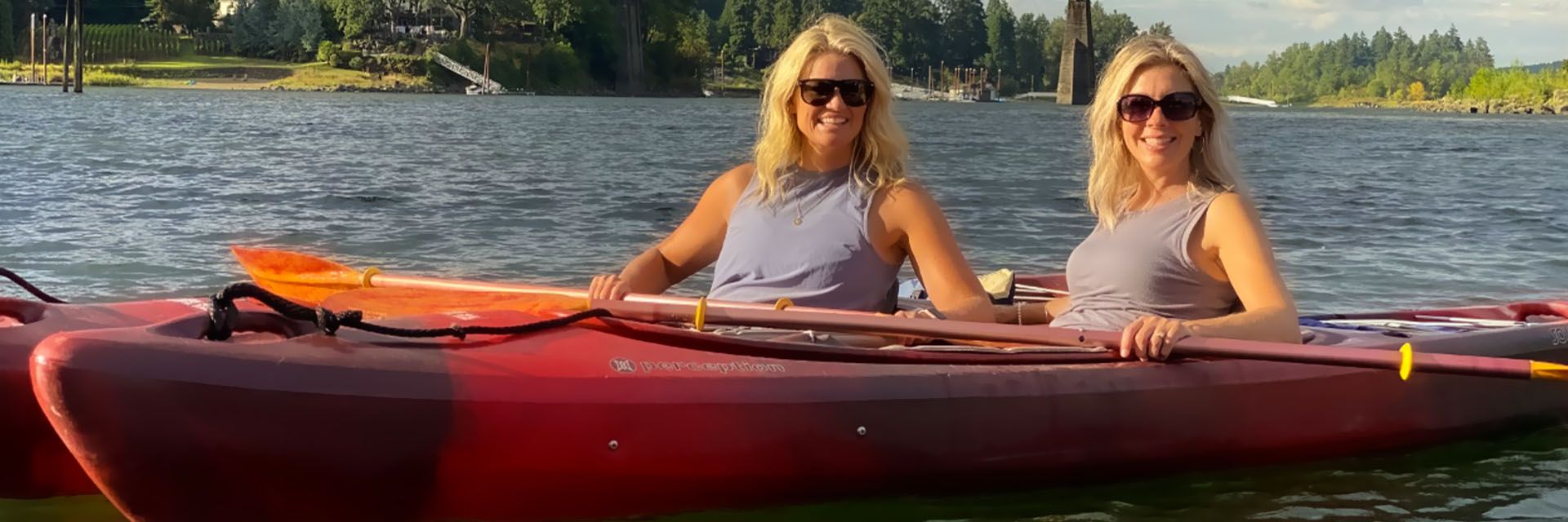 2 women sitting on kayaks